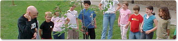 Children plant a tree at their elementary school.