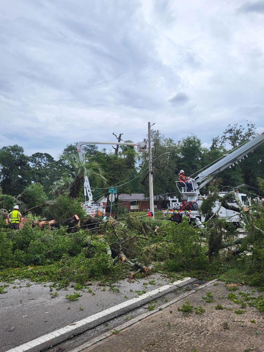 Storm Preparation Tips - aftermath of a storm in Florida with clean-up crews and linemen restoring electricity.